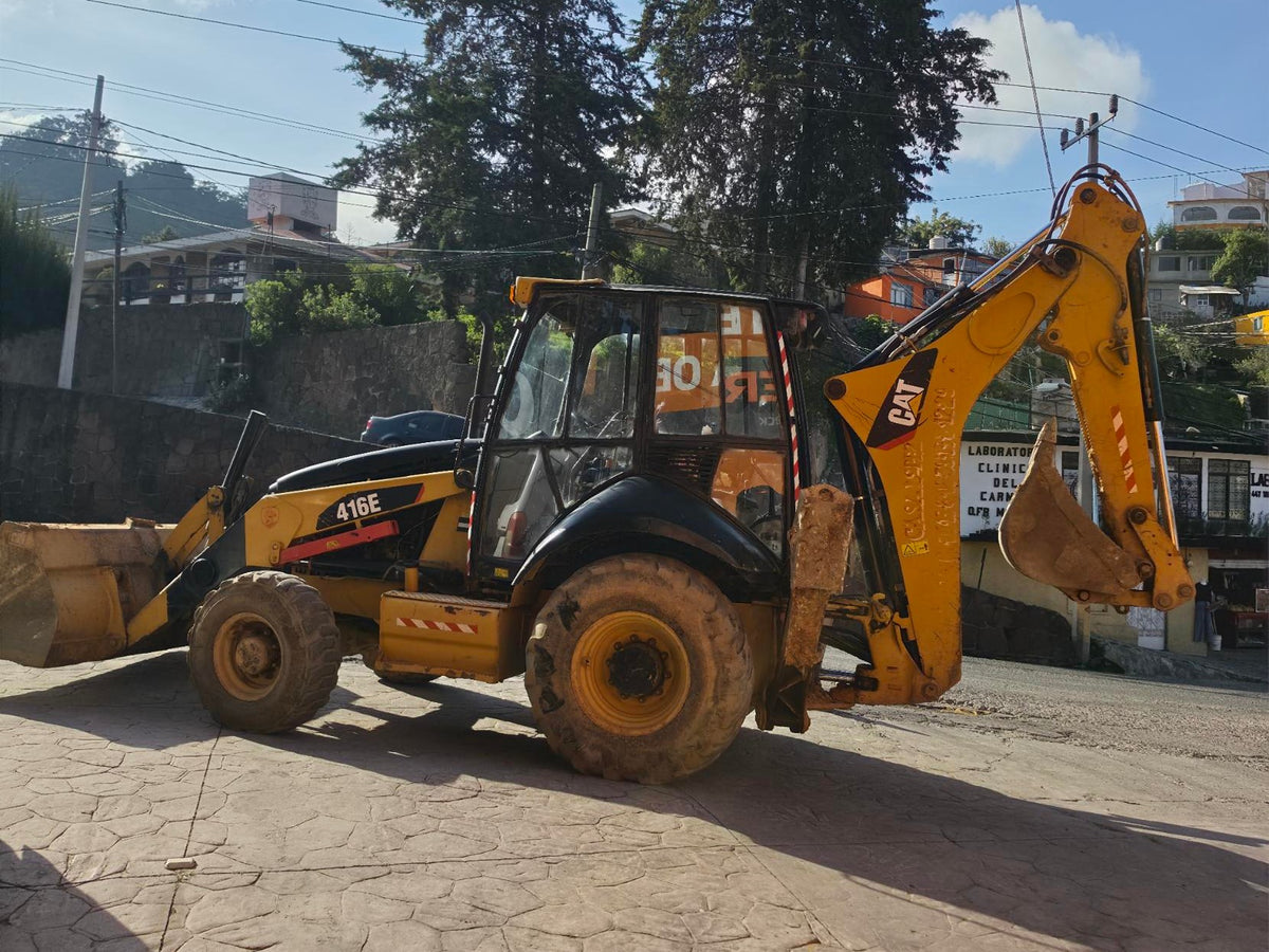 Retroexcavadora CAT 416E con cargador frontal y brazo excavador, vista lateral en Tlalpujahua