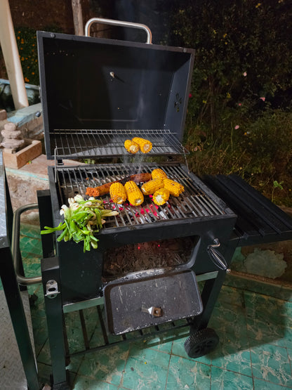 Carne asada, elotes y cebollitas en el asador de carbón con tapa Fiero
